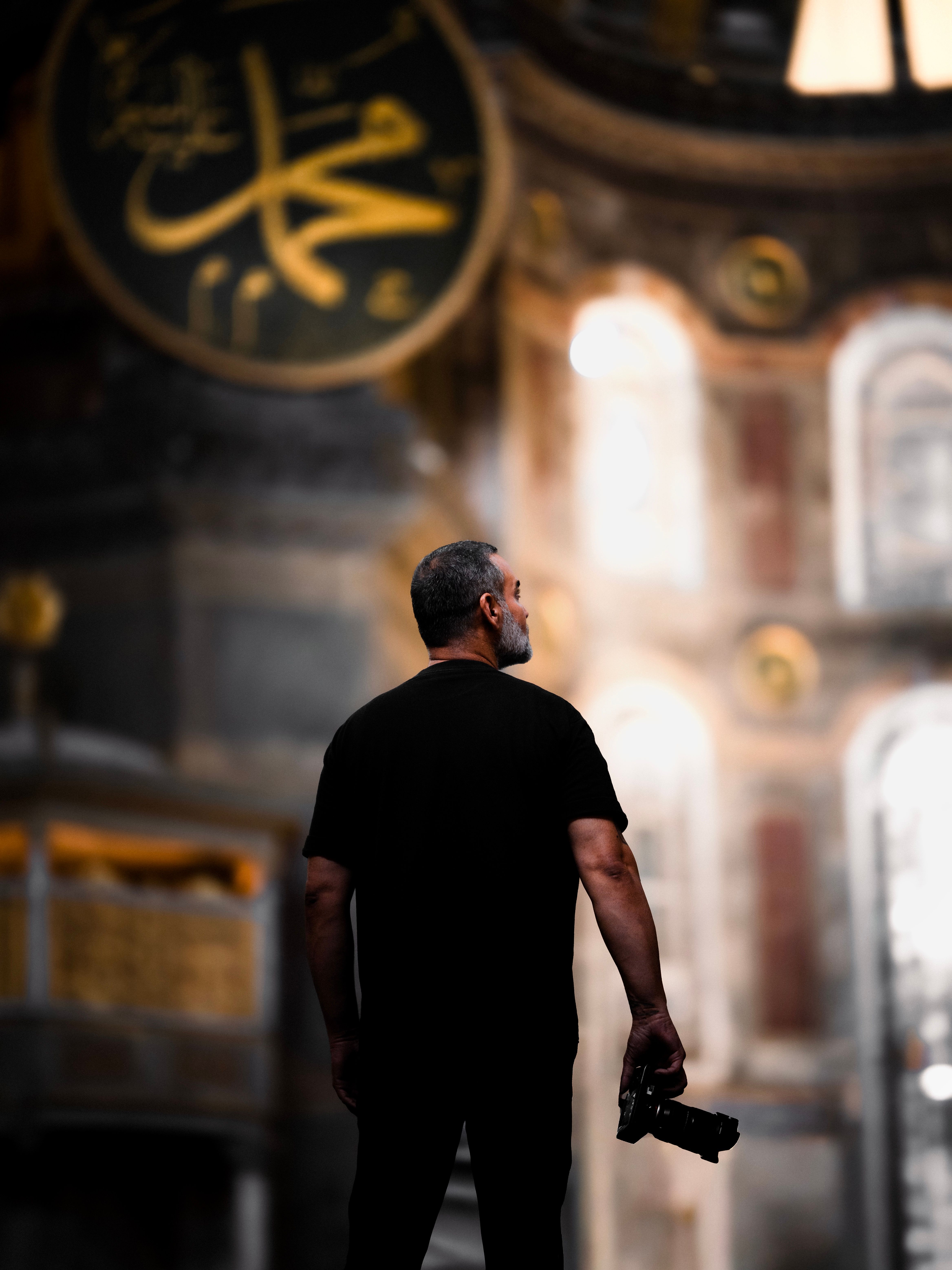 Photographer admires the grandeur of an iconic historical building interior, capturing its beauty with a camera.