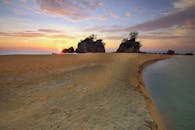 宁静的海滩上，美丽的日出映照着岩石结构和宁静的海水