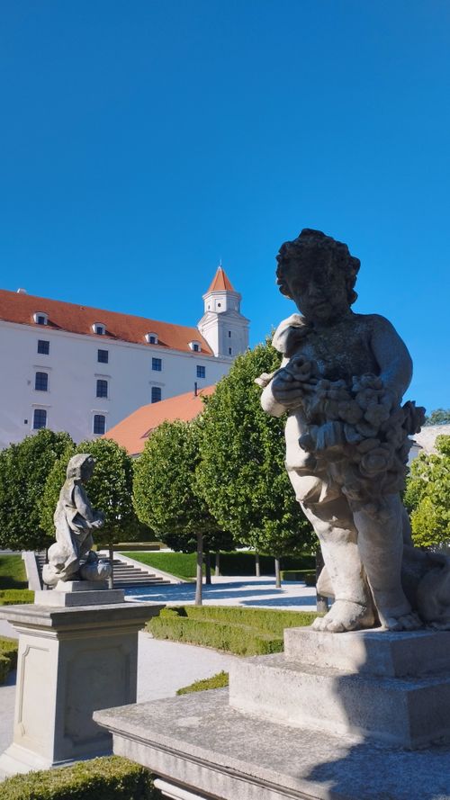 Free Statues adorn the Baroque garden at Bratislava Castle, showcasing classic European artistry. Stock Photo