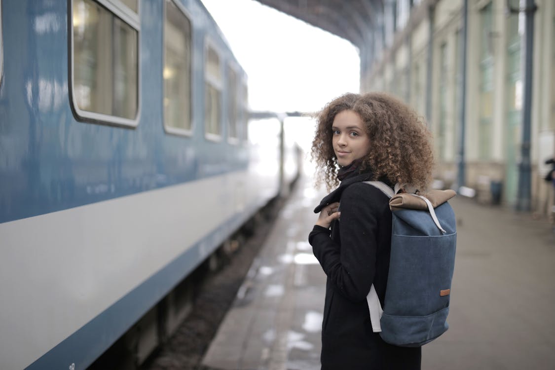 Free Girl in Black Jacket Standing Beside Train Stock Photo
