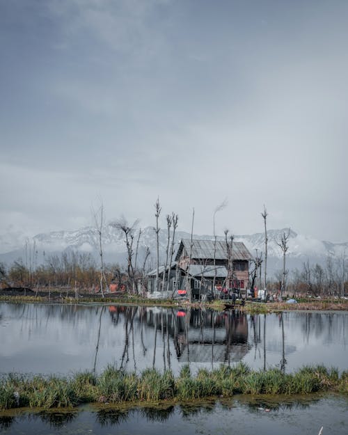 House Beside  Body of Water Near Mountain Covered With Snow