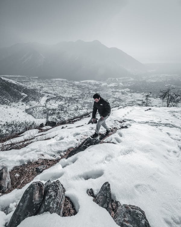 grátis Homem De Jaqueta Preta Andando Na Neve Foto profissional