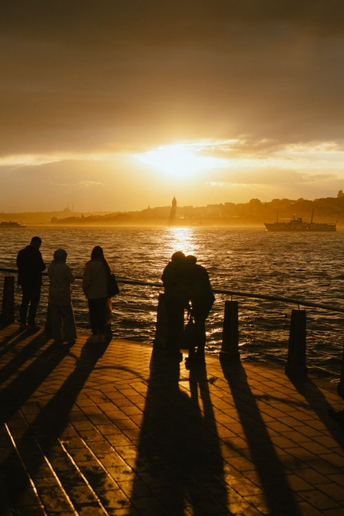 Free Stunning silhouette of people by the sea in Istanbul during a warm golden sunset. Stock Photo
