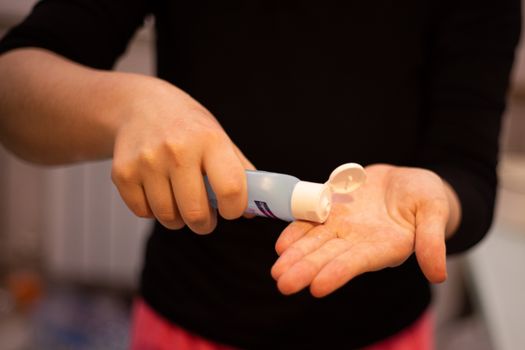 A close-up image of a woman applying hand sanitizer to maintain hygiene.