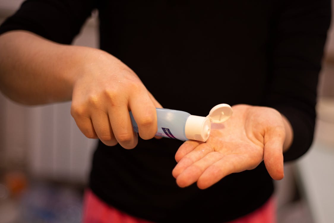 Person in Black Shirt Holding White Plastic Tube