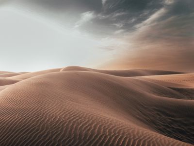 Sand dunes under a dark sky at dawn — photo by Sharad Bhat on Pexels
