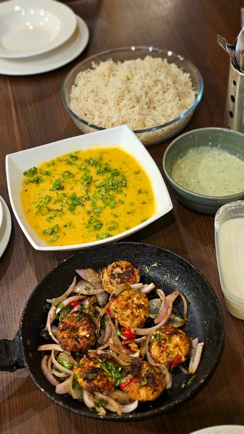 Free A top view of a traditional Indian meal with rice, curry, and cutlets. Stock Photo
