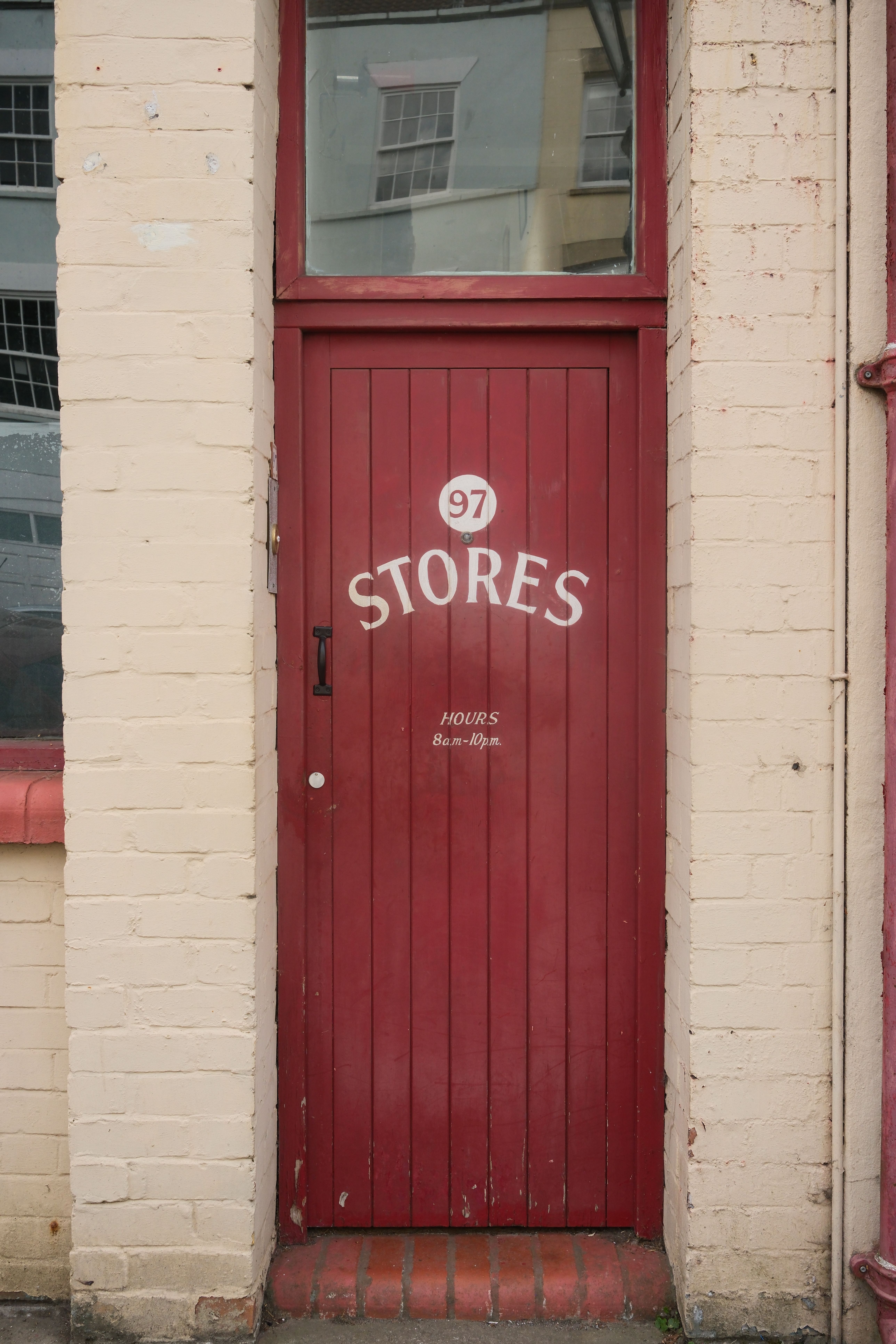 A quaint red door labeled 'Stores' in a brick building in Bristol, England.