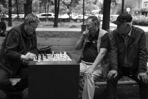 Free Black and white photo of three elderly men playing chess outdoors in Bishkek, Kyrgyzstan. Stock Photo