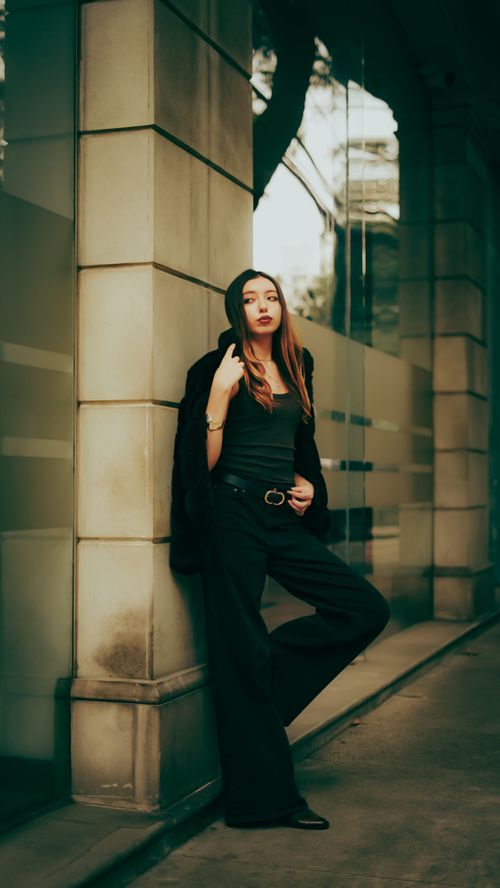Free Stylish woman posing outdoors against a modern building, exuding confidence and elegance. Stock Photo