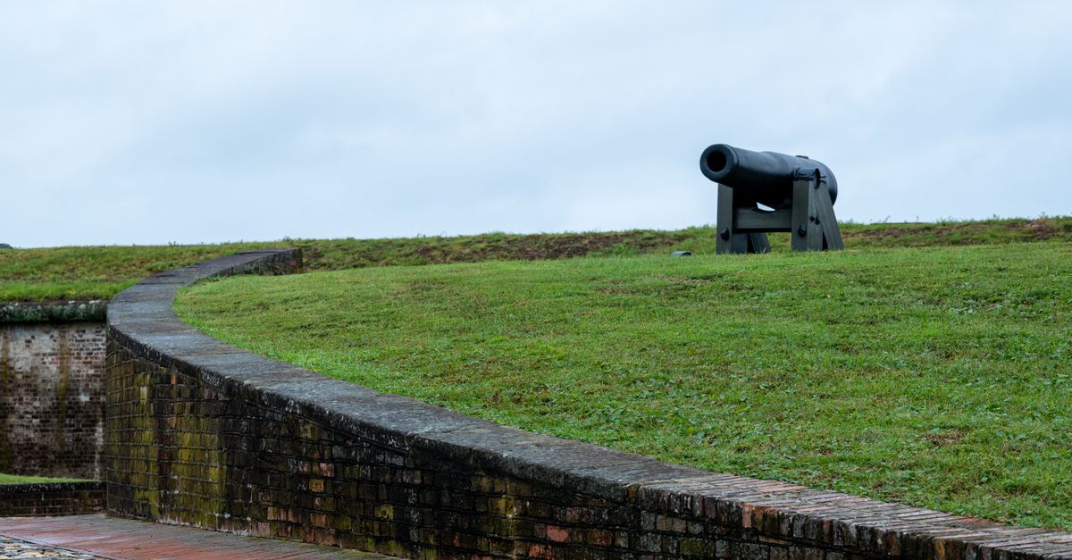 A scenic view of a historic cannon on grassy terrain at Fort Macon, North Carolina.
