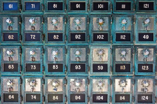 Free Rows of antique metal post office boxes with numbered dials and ornate designs. Stock Photo