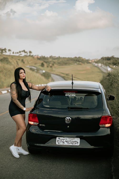 Free Woman In Black Tank Top Standing Beside A Car Stock Photo