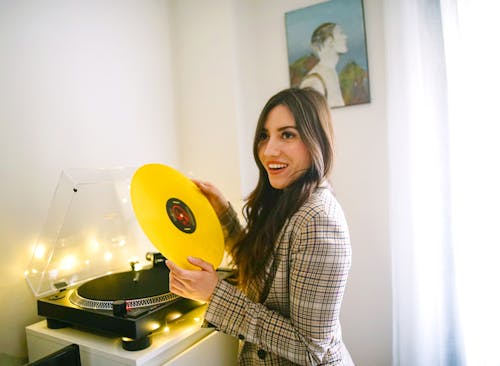 Wanita Memegang Rekaman Vinyl Kuning