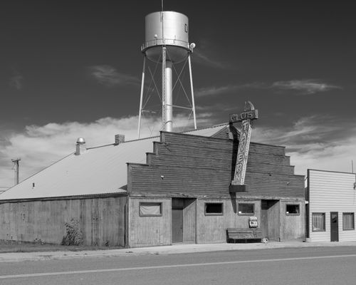 Free Black and white photo of a classic tavern with water tower in rural Montana. Stock Photo