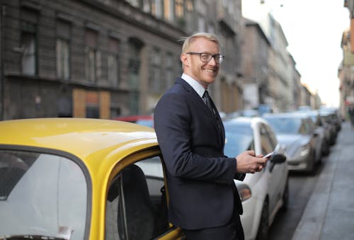 Free Man in Navy Blue Suit Standing Beside Yellow Car Stock Photo