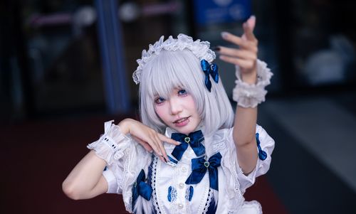 Free Cosplayer dressed in Victorian-style costume with lace and bows, striking a pose outdoors. Stock Photo