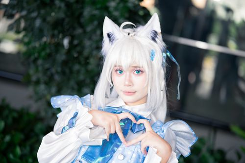 Free A captivating cosplay featuring an anime character with white hair and cat ears, posed in an indoor setting. Stock Photo