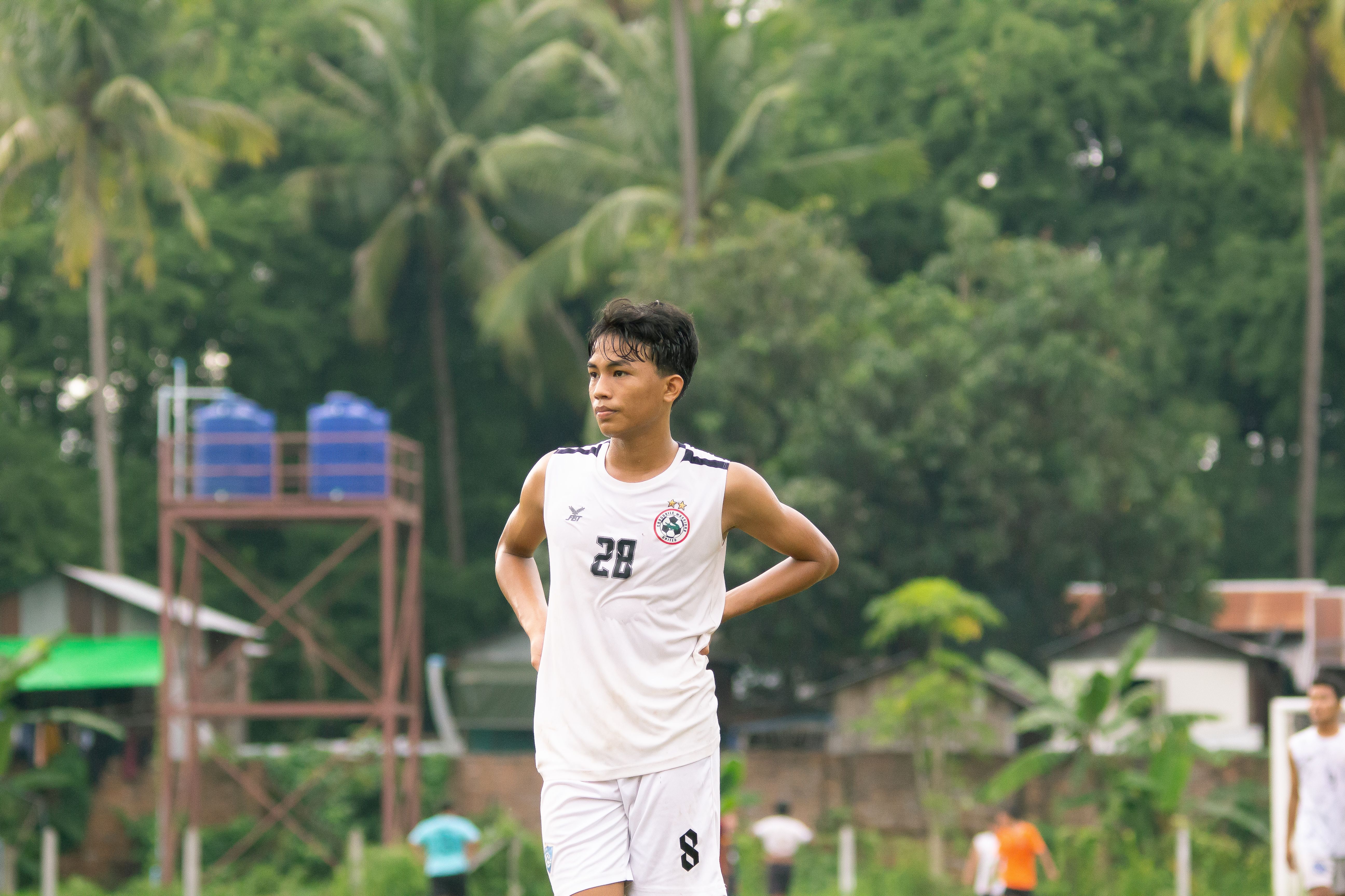 Focused soccer player stands on a field during a match in Myawaddy, Myanmar.