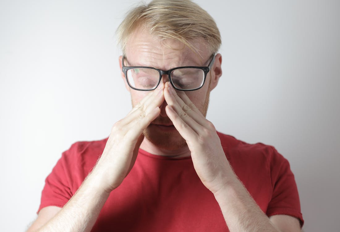 Free Exhausted mature man rubbing nose bridge after wearing glasses near gray wall Stock Photo