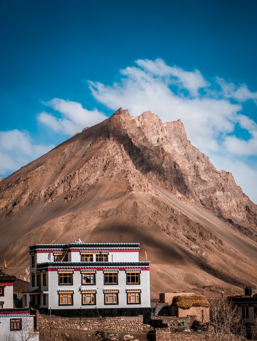 Free Stunning view of a traditional Tibetan-style building against a backdrop of majestic mountains in India. Stock Photo