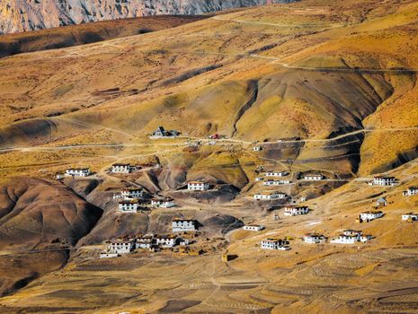 A breathtaking aerial view of a remote village in the Indian Himalayas against rugged terrain.