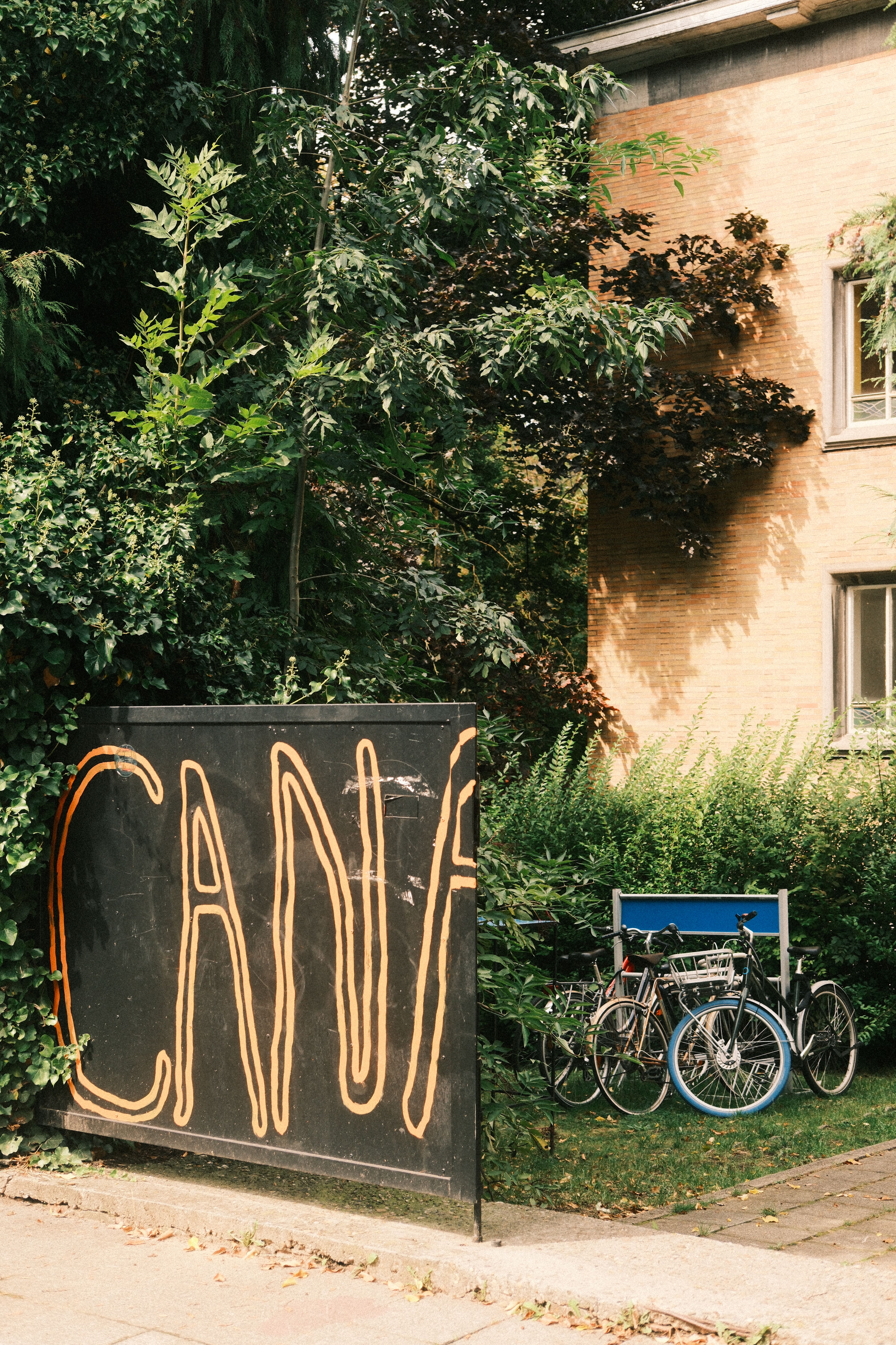 Charming outdoor urban scene with bicycles and 'CANA' sign next to a building in Brussels.