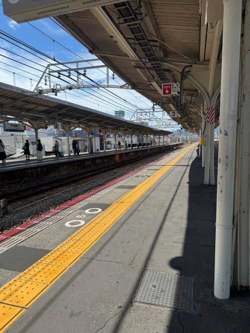 Free A bright day at a Japanese train station with clear skies and an empty platform. Stock Photo
