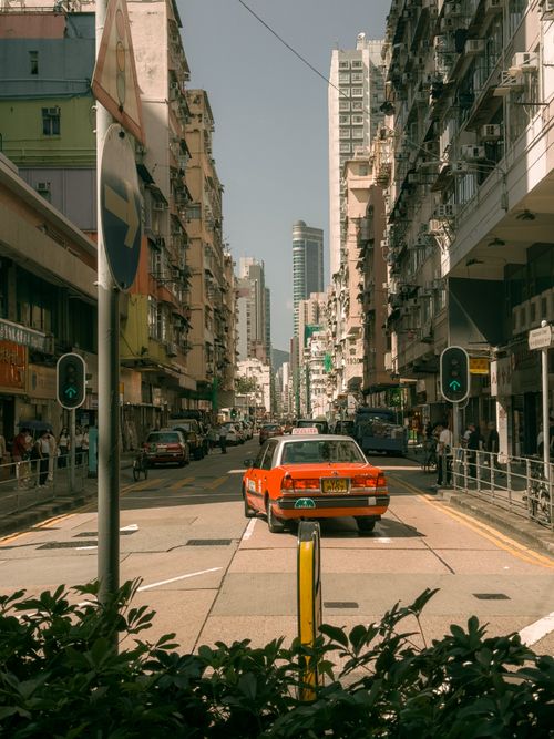 Free Explore the vibrant streets of Hong Kong with a classic red taxi against a backdrop of high-rise buildings. Stock Photo