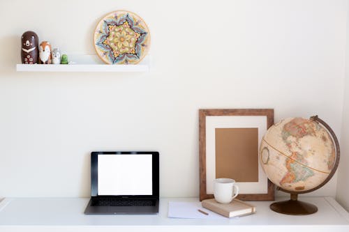 Interior of cozy home office with netbook frame globe organizer and vintage decor elements