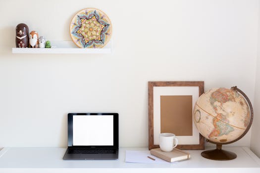 Minimalist home workspace featuring a blank laptop screen and a vintage globe.