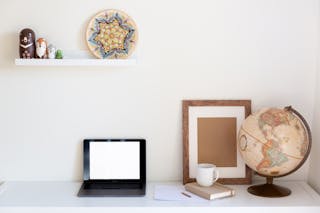 Interior of cozy home office with netbook frame globe organizer and vintage decor elements