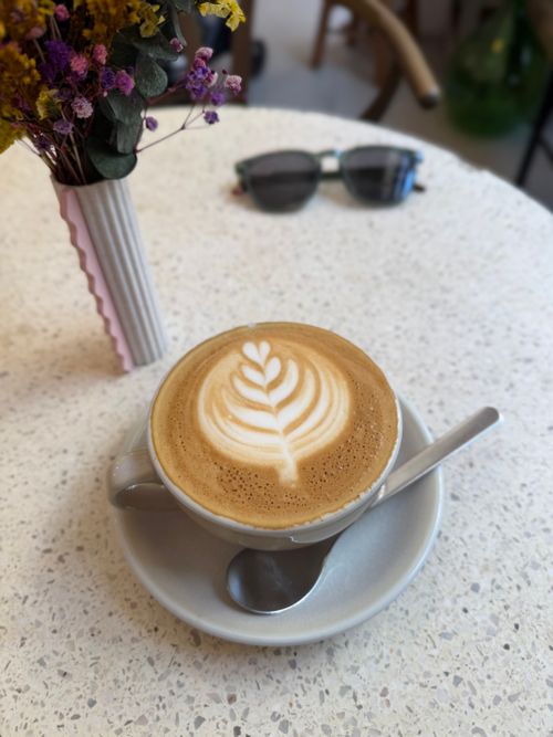 Free A beautifully crafted latte art on a cappuccino in an inviting café. Stock Photo