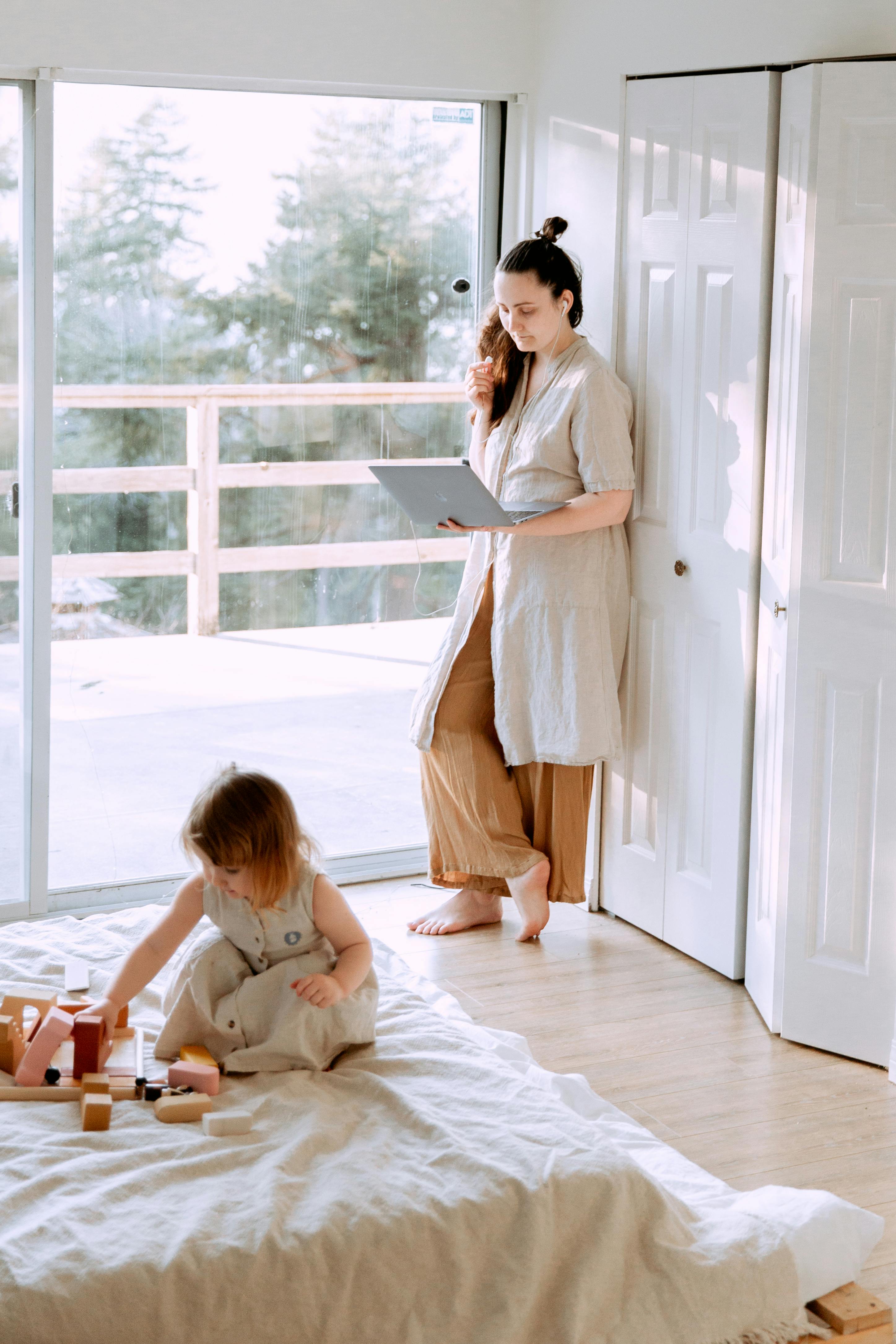 woman using laptop in bedroom with daughter