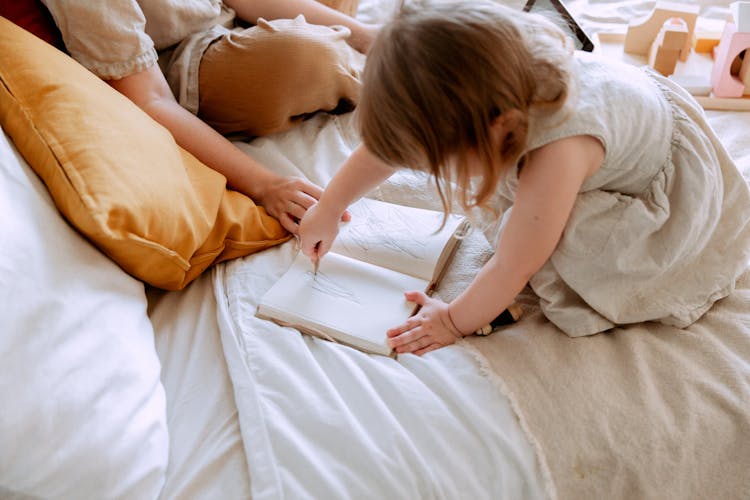 Girl Drawing In Notebook In Bed