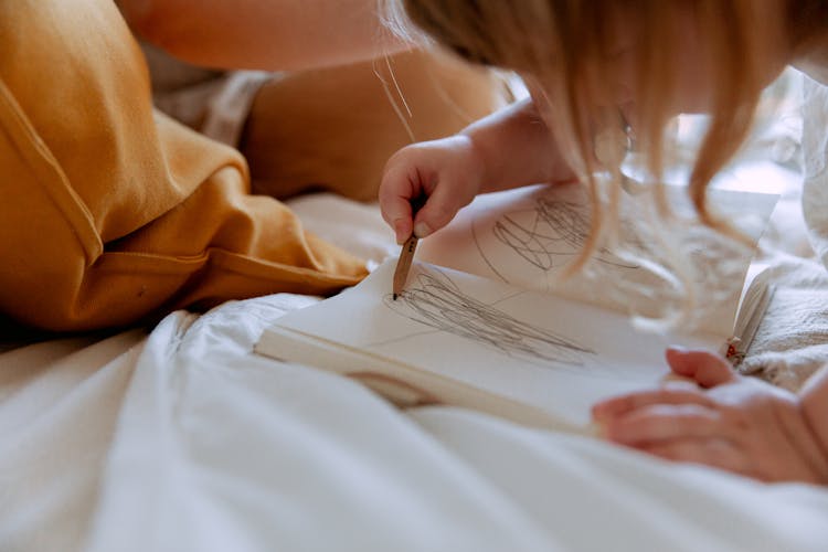 Small Kid Attentively Drawing In Notebook