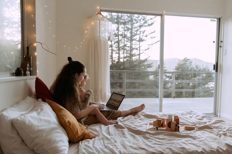 Mother With Small Daughter Surfing Laptop