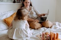 Mother talking with small daughter in bedroom