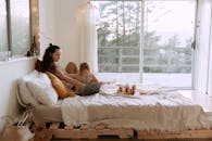 阳光普照的舒适卧室里，一对母女正亲密地共用一台笔记本电脑