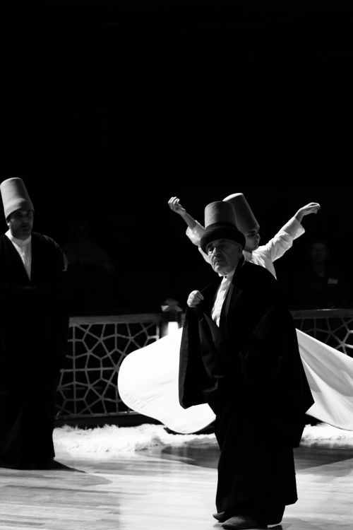 Free Black and white image of traditional Sufi whirling dervishes ceremony with dancers spinning. Stock Photo