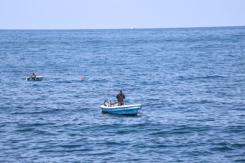 Free A serene scene of fishermen in boats on the Mediterranean Sea near Beirut, Lebanon, showcasing calm blue waters. Stock Photo