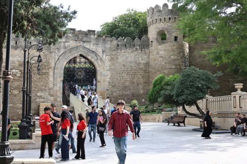 Free A bustling scene at the old city fortress wall in Baku, Azerbaijan, featuring tourists and locals. Stock Photo