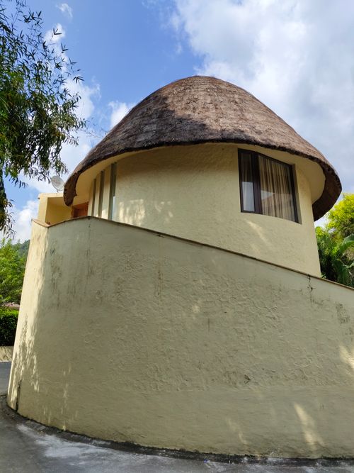 Free A round house with a thatched roof and smooth walls under a blue sky. Stock Photo