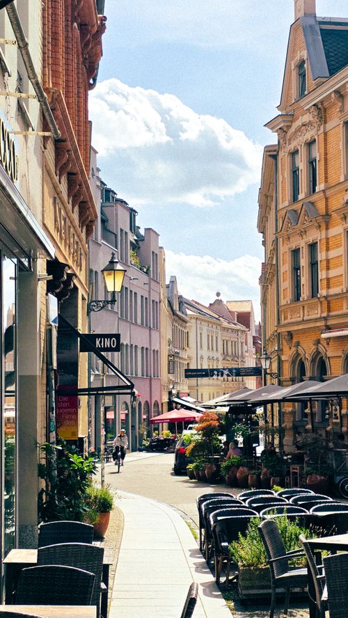 Free Sunny day on a lively street in Halle, Germany with cafes and historic architecture. Stock Photo