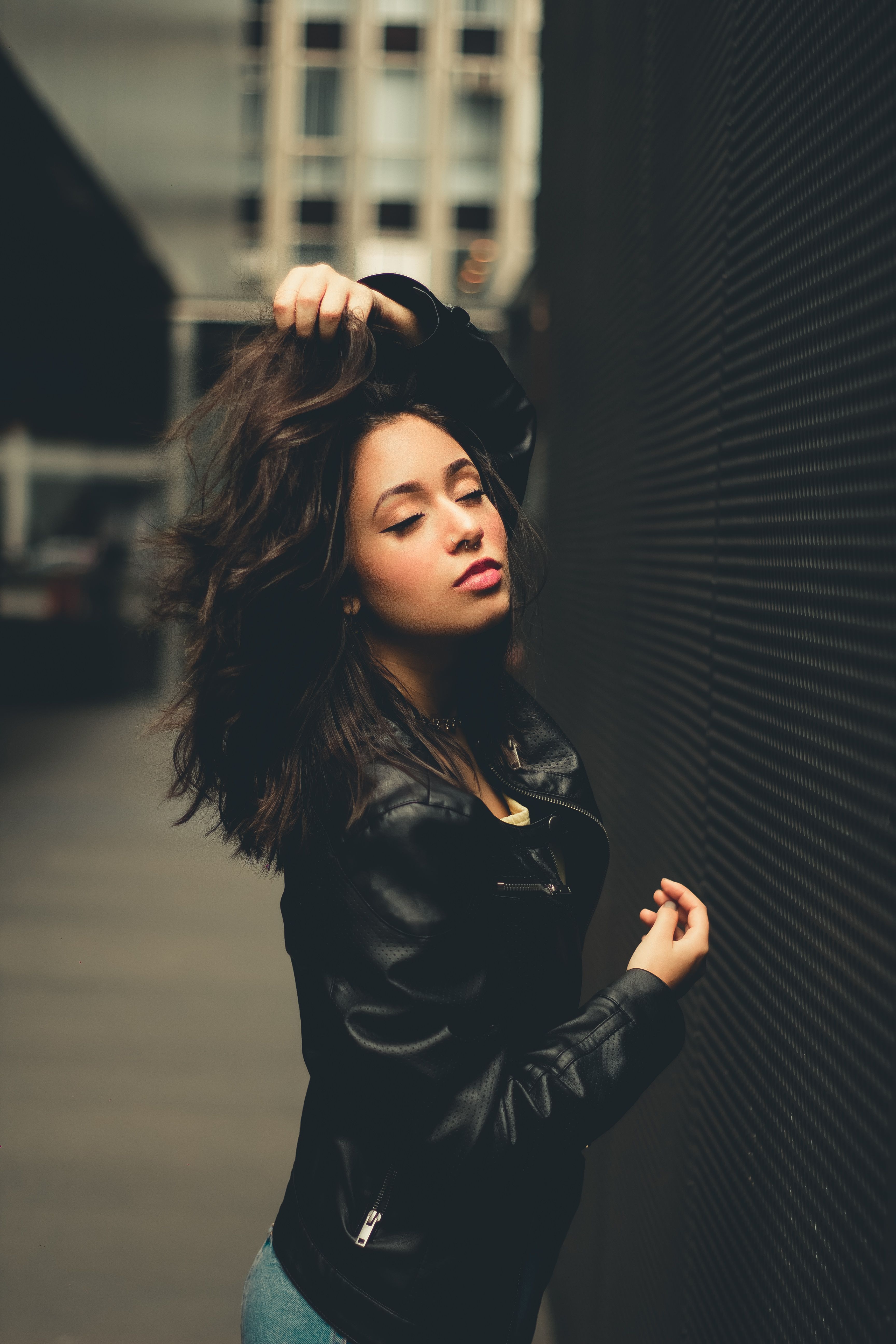 Woman in Black Leather Jacket Standing Near Black Wall · Free Stock Photo