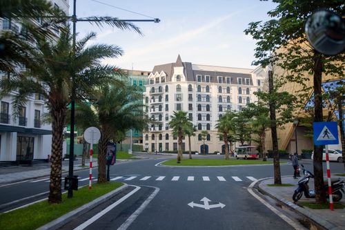 Free Scenic urban view featuring elegant architecture, palm trees, and quiet street at daytime. Stock Photo