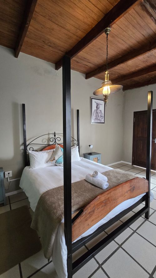 Free Elegant bedroom interior with rustic wooden ceiling and four-poster bed design. Stock Photo