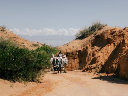 Free Group of people hiking through a stunning canyon path in Tosor, Issyk-Kul Region, Kyrgyzstan. Stock Photo