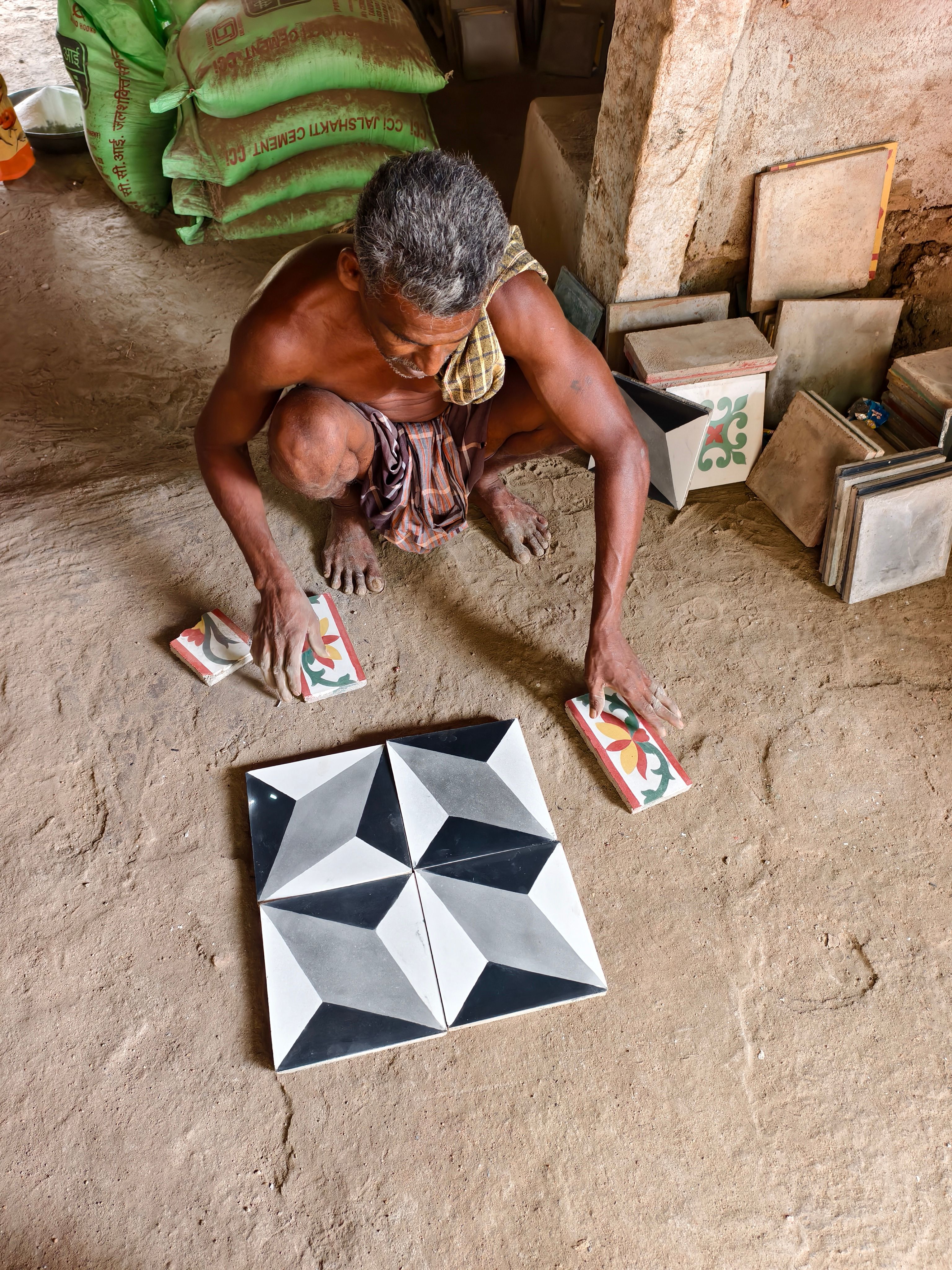 Artisan dispose des carreaux à motifs dans un atelier