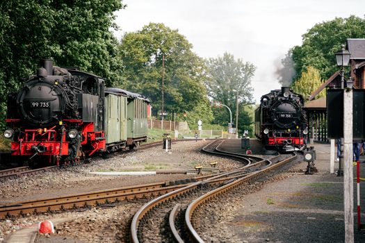 Two vintage steam trains at Bertsdorf-Hörnitz station, highlighting scenic railway travel.